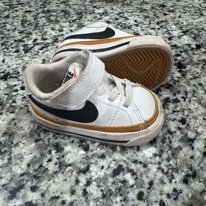 Nike Kids White Sneakers with Black Swoosh and Gold Stripe